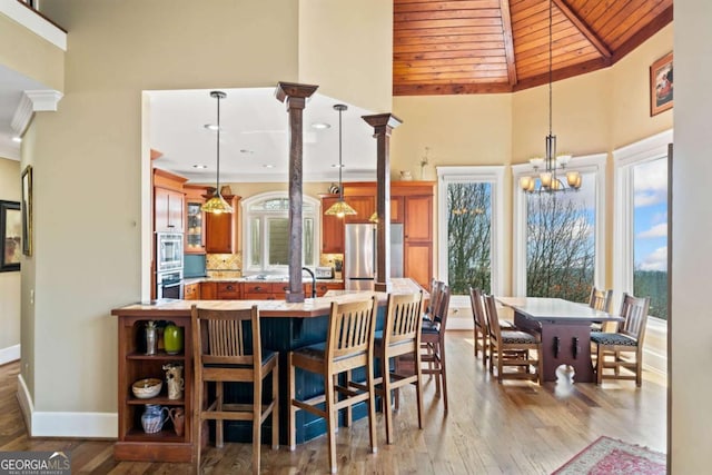 1043 Deer Run Rdg, Jasper, GA 30143 - dining room featuring wood ceiling, high vaulted ceiling, wood finished floors, a chandelier, and ornate columns