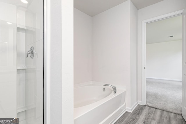 102 Avondale Blvd, Conyers, GA 30013 - bathroom featuring wood finished floors, a garden tub, and a stall shower