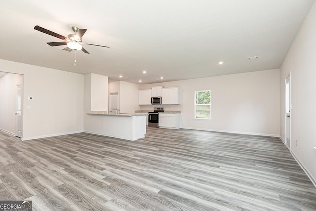 102 Avondale Blvd, Conyers, GA 30013 - unfurnished living room with light wood-type flooring, a ceiling fan, and recessed lighting