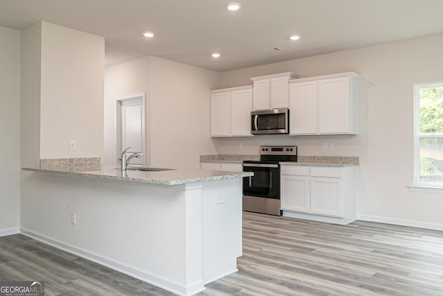 102 Avondale Blvd, Conyers, GA 30013 - kitchen with appliances with stainless steel finishes, light wood finished floors, white cabinetry, light stone countertops, and recessed lighting