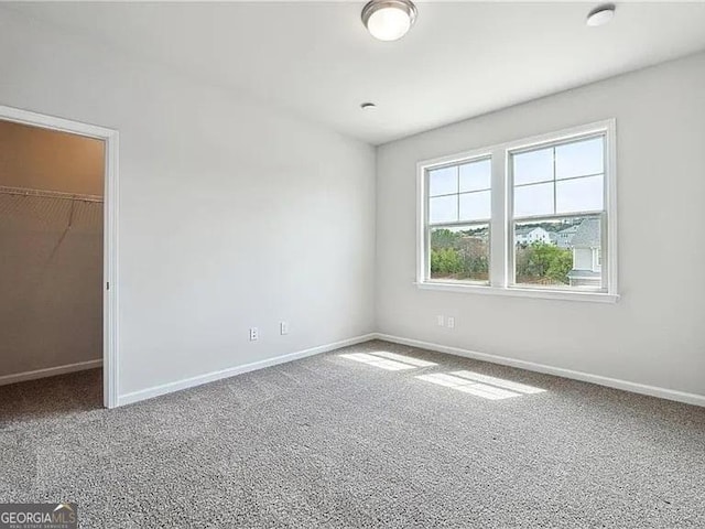 8415 Halford Way, Ball Ground, GA 30107 - unfurnished bedroom featuring a walk in closet, carpet floors, and a closet