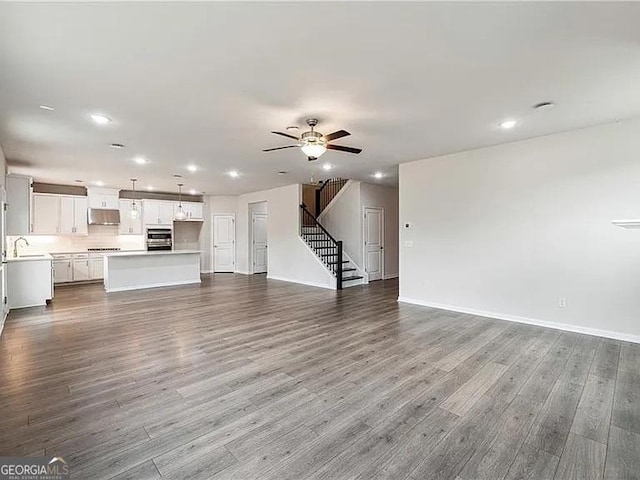 8415 Halford Way, Ball Ground, GA 30107 - unfurnished living room with stairs, ceiling fan, recessed lighting, and dark wood finished floors