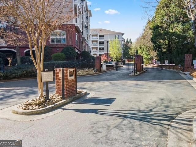 4333 Dunwoody Park Unit 2214, Atlanta, GA 30338 - view of asphalt road featuring a gate, curbs, and a gated entry