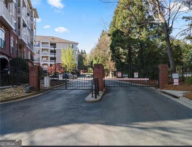 4333 Dunwoody Park Unit 2214, Atlanta, GA 30338 - view of asphalt road with a gate, a gated entry, and curbs