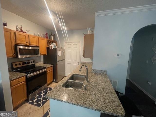 4333 Dunwoody Park Unit 2214, Atlanta, GA 30338 - kitchen featuring stainless steel appliances, arched walkways, a peninsula, a textured ceiling, and dark stone counters