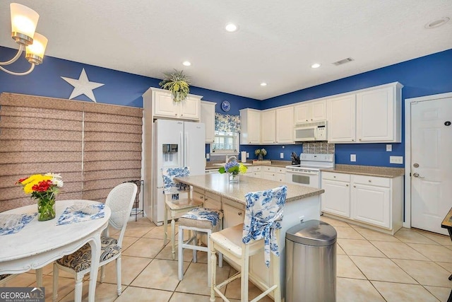 21 Hardwood Forest Cir, Brunswick, GA 31525 - kitchen with white appliances, white cabinets, light tile patterned flooring, a center island, and recessed lighting