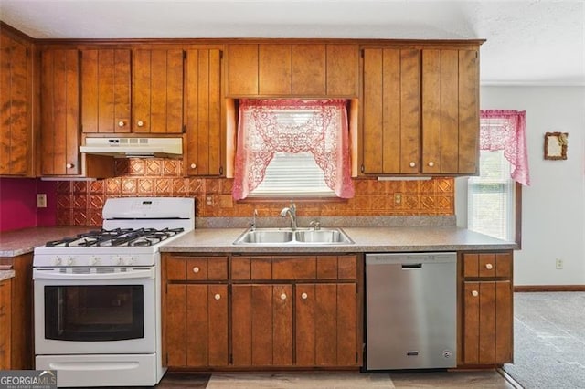 1159 Midland Dr NW, Acworth, GA 30102 - kitchen featuring dishwasher, white gas stove, under cabinet range hood, brown cabinetry, and tasteful backsplash