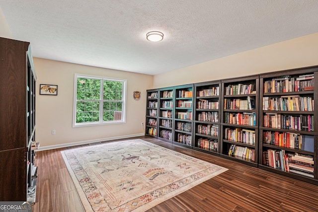 150 Buck Run E, Dahlonega, GA 30533 - living area featuring wall of books, wood finished floors, and a textured ceiling