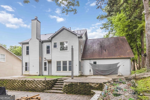 539 Riverbirch Trce, Stone Mountain, GA 30087 - back of house featuring a patio area, a chimney, and a garage