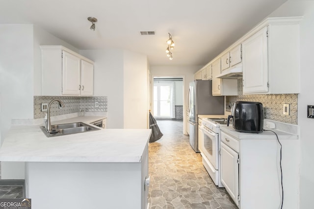 539 Riverbirch Trce, Stone Mountain, GA 30087 - kitchen with white gas stove, backsplash, light countertops, a peninsula, and white cabinetry