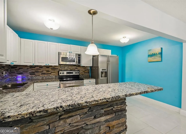 2917 W Clifton St, Tampa, FL 33614 - kitchen featuring stainless steel appliances, tasteful backsplash, white cabinets, dark stone countertops, and pendant lighting