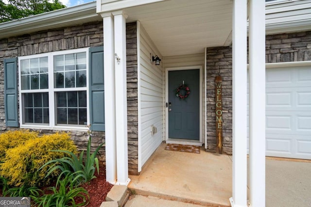 245 Weatherstone Pointe Dr, Woodstock, GA 30188 - doorway to property with stone siding, covered porch, and a garage