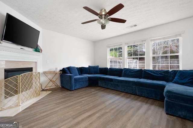 245 Weatherstone Pointe Dr, Woodstock, GA 30188 - living room featuring a textured ceiling, wood finished floors, a high end fireplace, and a ceiling fan
