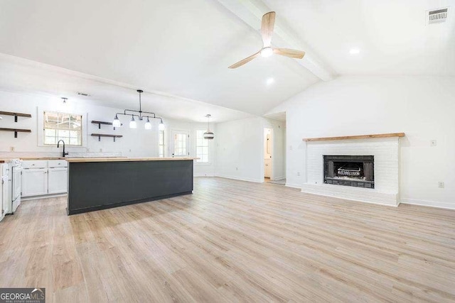 321 Riverbend Ct, Macon, GA 31211 - kitchen featuring open shelves, a ceiling fan, light countertops, light wood-style flooring, and a center island