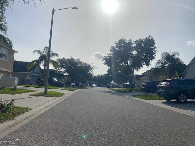 24910 Oakhaven Ct, Lutz, FL 33559 - view of asphalt road with a residential view, street lighting, and curbs