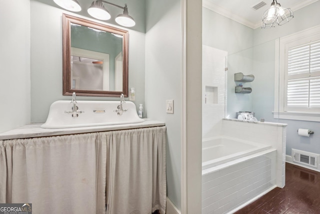 365 Seavy St, Senoia, GA 30276 - bathroom featuring a relaxing tiled tub, crown molding, and wood finished floors