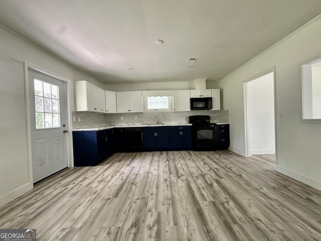 210 W Graham St, Mcrae-Helena, GA 31055 - kitchen featuring black appliances, white cabinetry, backsplash, light wood-style floors, and dark cabinetry
