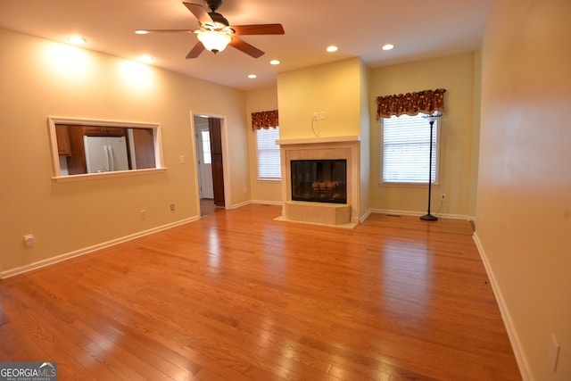 195 Twin Oaks Dr, Hampton, GA 30228 - unfurnished living room with light wood-type flooring, ceiling fan, a tile fireplace, and recessed lighting