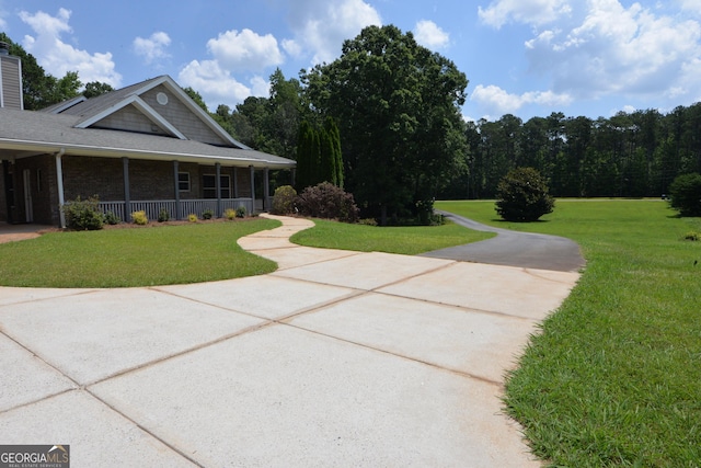 195 Twin Oaks Dr, Hampton, GA 30228 - view of side of home featuring a yard, covered porch, and a chimney