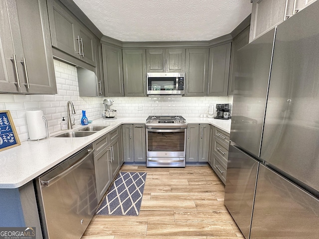 1501 E Main St, Hogansville, GA 30230 - kitchen with appliances with stainless steel finishes, light wood finished floors, gray cabinetry, light countertops, and a textured ceiling