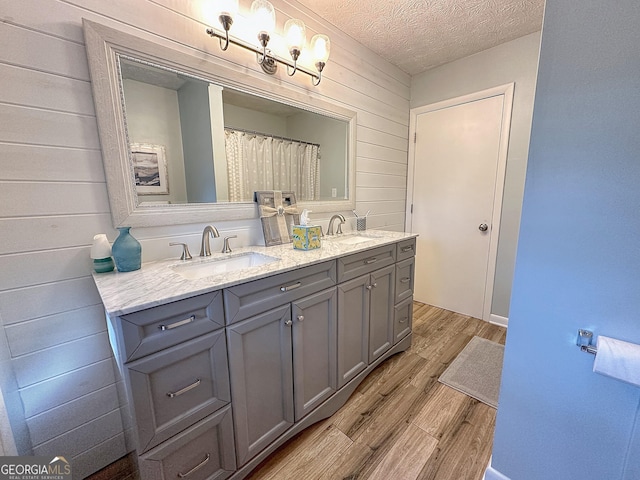 1501 E Main St, Hogansville, GA 30230 - full bathroom with wood finished floors, double vanity, wood walls, and a textured ceiling