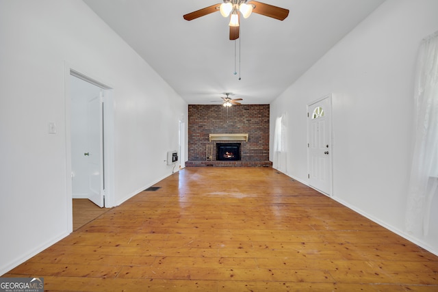 303 Oak Way Dr, Eastanollee, GA 30538 - unfurnished living room featuring a ceiling fan, light wood-style floors, and a brick fireplace