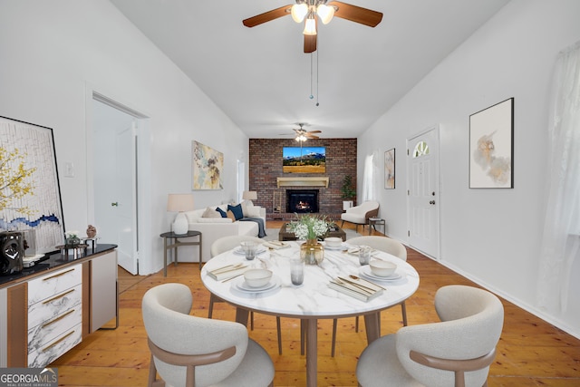 303 Oak Way Dr, Eastanollee, GA 30538 - dining room with a ceiling fan, a brick fireplace, and light wood-style flooring