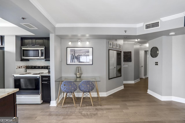 795 Hammond Dr Unit 1012, Atlanta, GA 30328 - kitchen with stainless steel microwave, white electric stove, light countertops, light wood finished floors, and tasteful backsplash