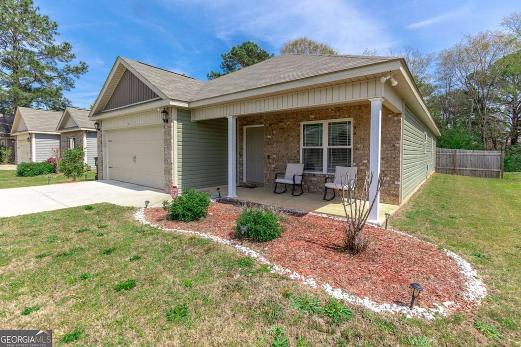 104 Hughes Dr, Warner Robins, GA 31093 - ranch-style house with covered porch, driveway, an attached garage, and brick siding
