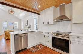 1016 Seiler Ave, Savannah, GA 31401 - kitchen with wall chimney range hood, stainless steel appliances, wooden ceiling, a peninsula, and light countertops