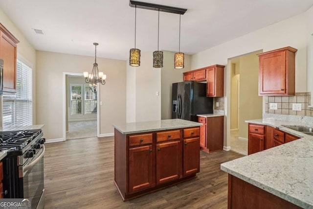 1755 Rutland Pass Dr, Lawrenceville, GA 30045 - kitchen featuring black fridge with ice dispenser, stainless steel gas range, a chandelier, decorative backsplash, and dark wood-type flooring