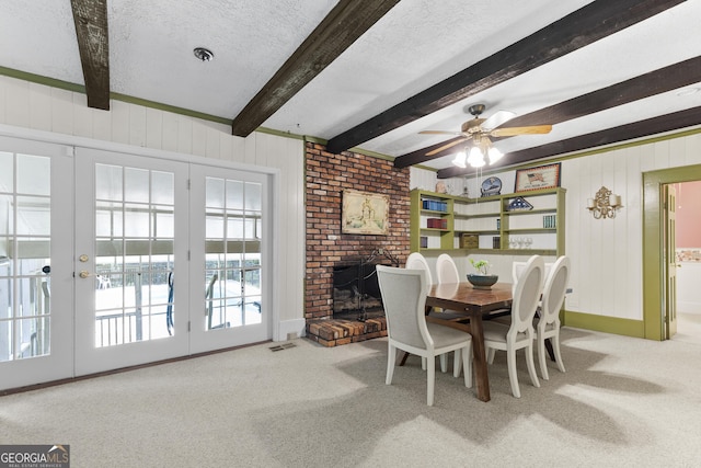 2540 Sugar Hill Rd, Unadilla, GA 31091 - carpeted dining space featuring beam ceiling, a textured ceiling, ceiling fan, wood walls, and a brick fireplace