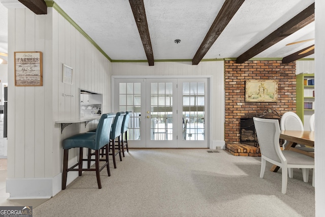 2540 Sugar Hill Rd, Unadilla, GA 31091 - dining space with beamed ceiling, french doors, carpet, a textured ceiling, and wood walls