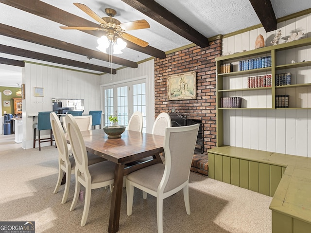 2540 Sugar Hill Rd, Unadilla, GA 31091 - dining area featuring beam ceiling, light colored carpet, a ceiling fan, wooden walls, and a textured ceiling