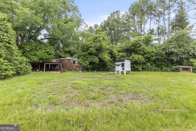 2540 Sugar Hill Rd, Unadilla, GA 31091 - view of yard with exterior structure, an outdoor structure, and view of wooded area
