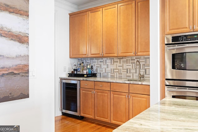 196 Mystic Ct, Atlanta, GA 30342 - kitchen featuring beverage cooler, stainless steel double oven, tasteful backsplash, light stone counters, and crown molding