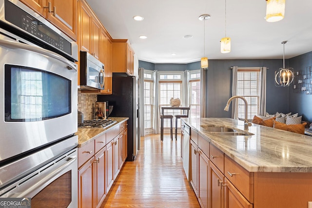 196 Mystic Ct, Atlanta, GA 30342 - kitchen with stainless steel appliances, light wood-type flooring, a center island with sink, light stone countertops, and recessed lighting