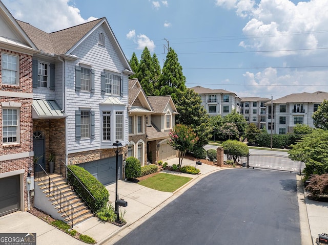 196 Mystic Ct, Atlanta, GA 30342 - view of front of house featuring a standing seam roof, driveway, roof with shingles, a metal roof, and a gate