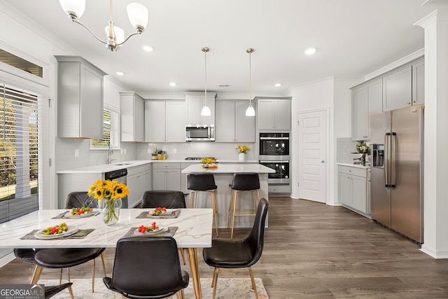 683 Edgar, Hampton, GA 30228 - kitchen with appliances with stainless steel finishes, gray cabinetry, crown molding, backsplash, and a center island