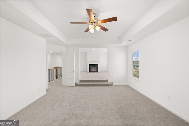 683 Edgar, Hampton, GA 30228 - unfurnished living room featuring a tray ceiling, ceiling fan, a warm lit fireplace, and carpet floors