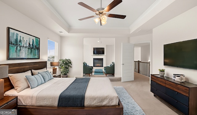683 Edgar, Hampton, GA 30228 - bedroom featuring a raised ceiling, light colored carpet, a glass covered fireplace, ornamental molding, and ceiling fan
