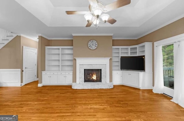 3737 Falls Trl, Winston, GA 30187 - unfurnished living room with light wood-type flooring, a tray ceiling, a fireplace, ceiling fan, and ornamental molding
