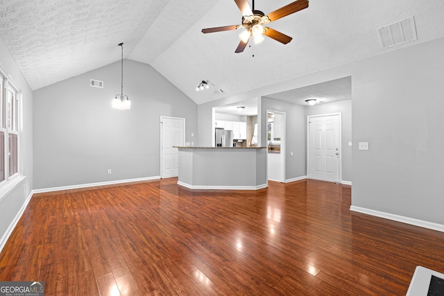 80 Austin Woods Dr, Senoia, GA 30276 - unfurnished living room featuring a ceiling fan, wood finished floors, vaulted ceiling, and a textured ceiling
