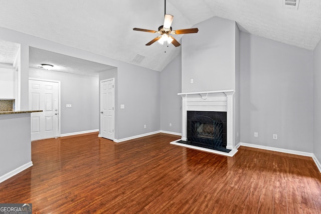 80 Austin Woods Dr, Senoia, GA 30276 - unfurnished living room featuring a tile fireplace, ceiling fan, wood finished floors, lofted ceiling, and a textured ceiling