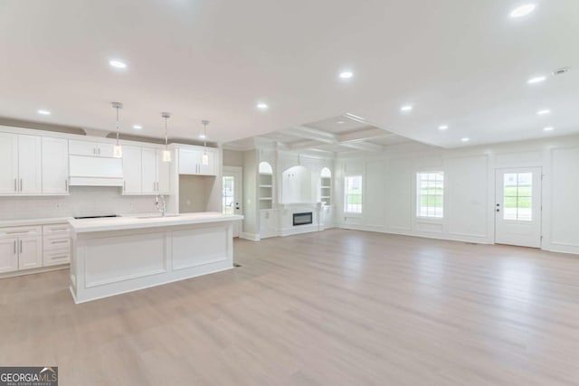 540 Sunset Ave, Comer, GA 30629 - kitchen featuring light wood finished floors, white cabinets, a kitchen island with sink, recessed lighting, and light countertops