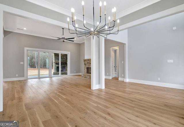 194 Forest Berry Ct Unit 98M2, Newnan, GA 30265 - unfurnished living room with a chandelier, light wood-style flooring, a high ceiling, and a fireplace