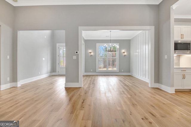 194 Forest Berry Ct Unit 98M2, Newnan, GA 30265 - unfurnished living room featuring crown molding, a chandelier, and light wood-style flooring