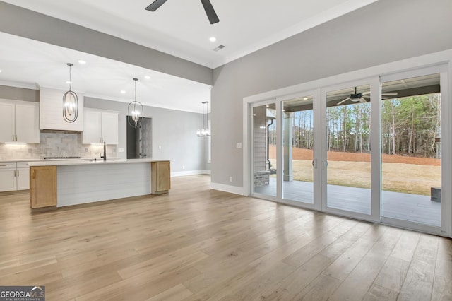 194 Forest Berry Ct Unit 98M2, Newnan, GA 30265 - kitchen featuring ceiling fan, light countertops, backsplash, light wood-type flooring, and crown molding