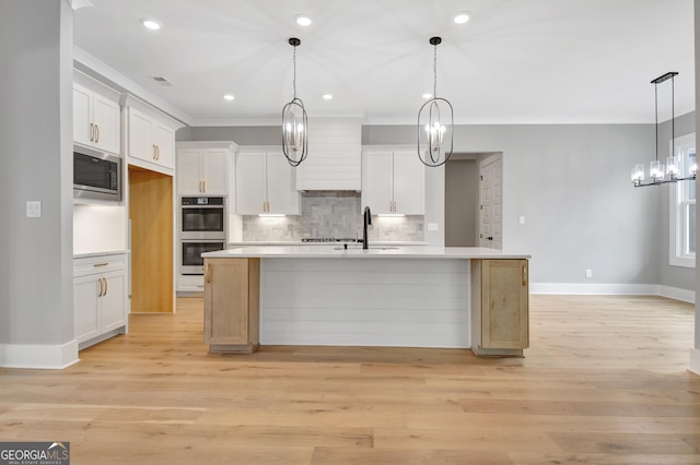 194 Forest Berry Ct Unit 98M2, Newnan, GA 30265 - kitchen featuring stainless steel appliances, a chandelier, ornamental molding, tasteful backsplash, and white cabinetry