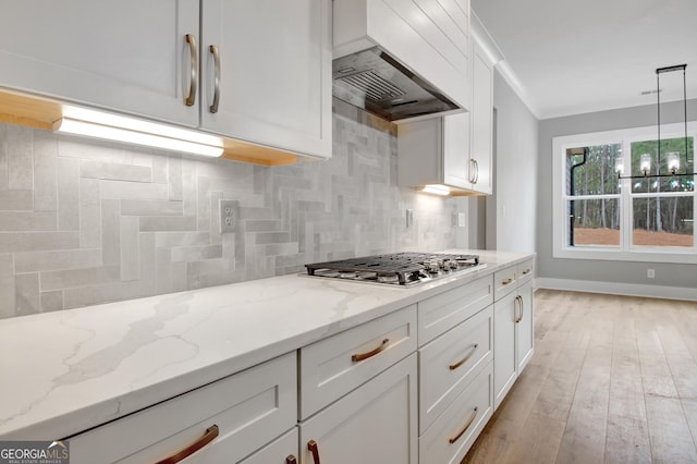 194 Forest Berry Ct Unit 98M2, Newnan, GA 30265 - kitchen featuring stainless steel gas cooktop, tasteful backsplash, white cabinetry, custom range hood, and light stone counters